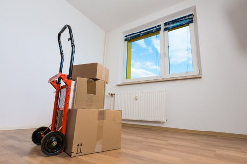 Removal crew carrying household items through a central London apartment building